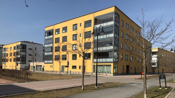 Inflyttningsklar lägenhet i modernt flerbostadshus med gul fasad och balkonger