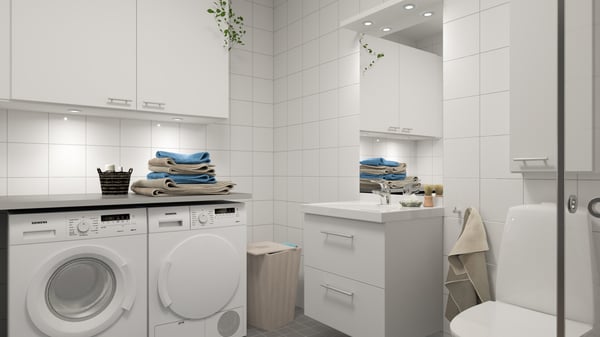Modernt badrum med tvättmaskin, torktumlare, handfat och vit kakelvägg
