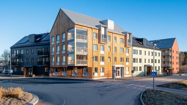 Inflyttningsklar lägenhet i modernt flerbostadshus med balkonger och träfasad