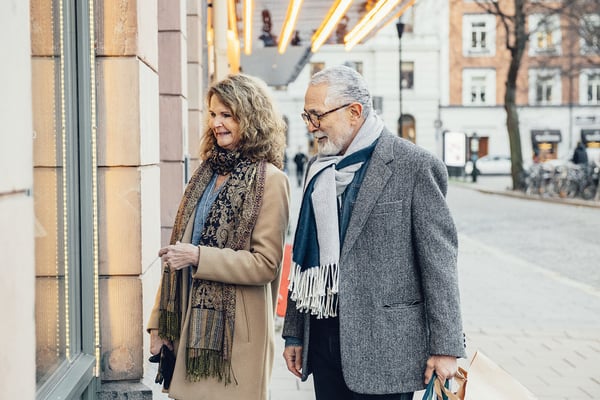 Äldre par utanför en butik på en stadsgata