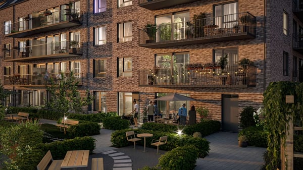 Fasad med balkonger, grön innergård och gemensamma uteplatser i ett modernt flerbostadshus