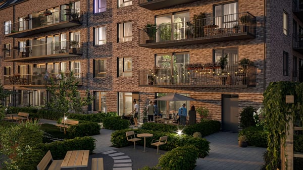 Fasad med balkonger, grön innergård och gemensamma uteplatser i ett modernt flerbostadshus
