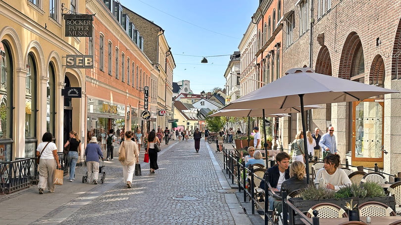 Gågata i Lund med butiker, uteservering och många människor i stadsmiljö