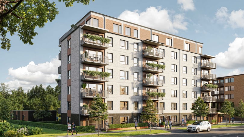 Flerfamiljshus i modern arkitektur med balkonger, grönska och gångstigar i förgrunden under en klar himmel