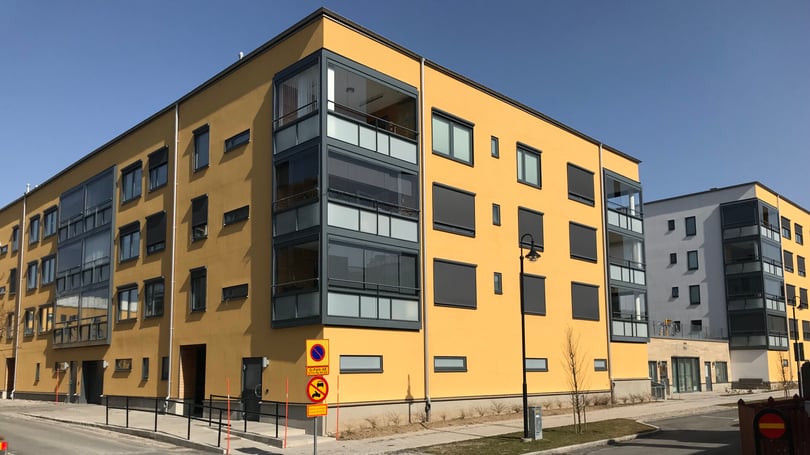 Lägenheter i modernt flerbostadshus med gul fasad och balkonger
