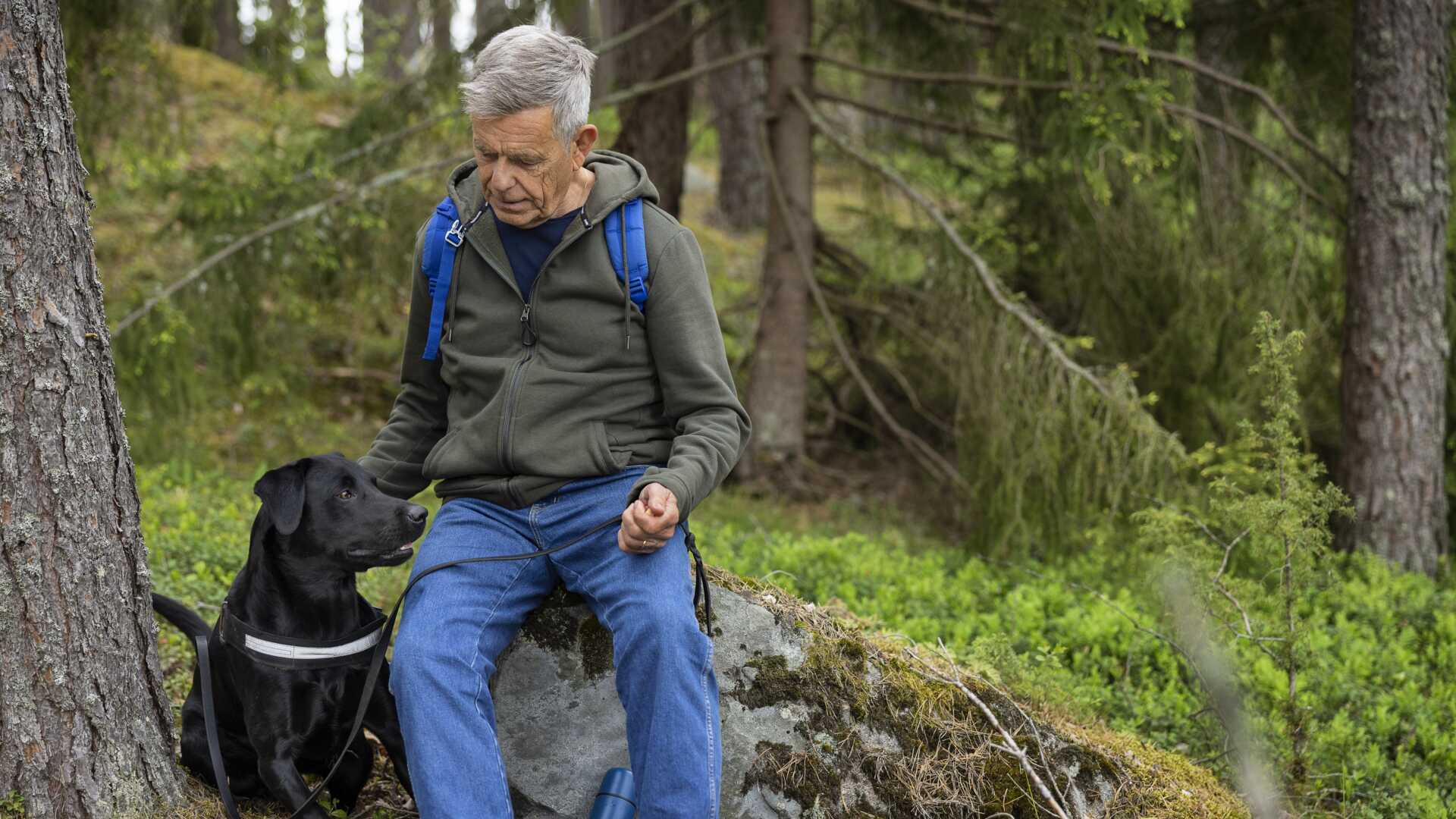 Man med hund i skogen