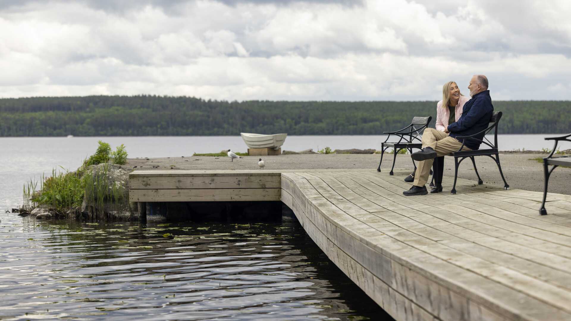 Par sitter på bänk på brygga