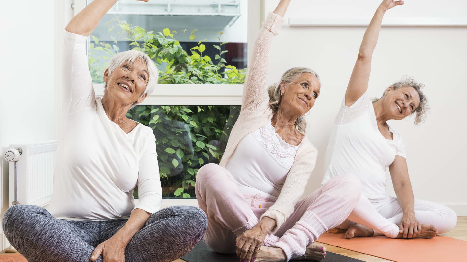 Tre kvinnor utövar yoga